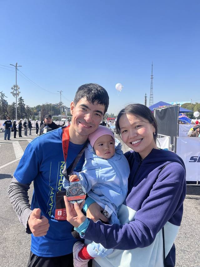 Alisher with his family and his finisher medal after the Almaty Marathon